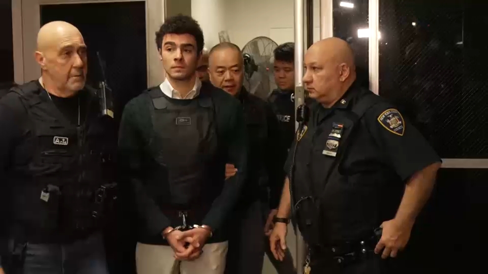 Source-feed image associated with Mangione court appearance pushed after paperwork filing delay, purpose remains shrouded in secrecy