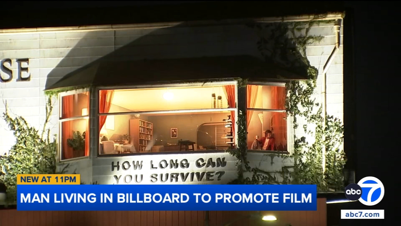 Source-feed image associated with Man living inside billboard on Sunset Boulevard in LA to promote film draws spectators