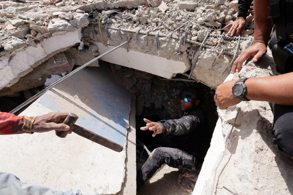 Source-feed image associated with Neighbors dig through Venezuela rubble to search for loved ones as death toll climbs