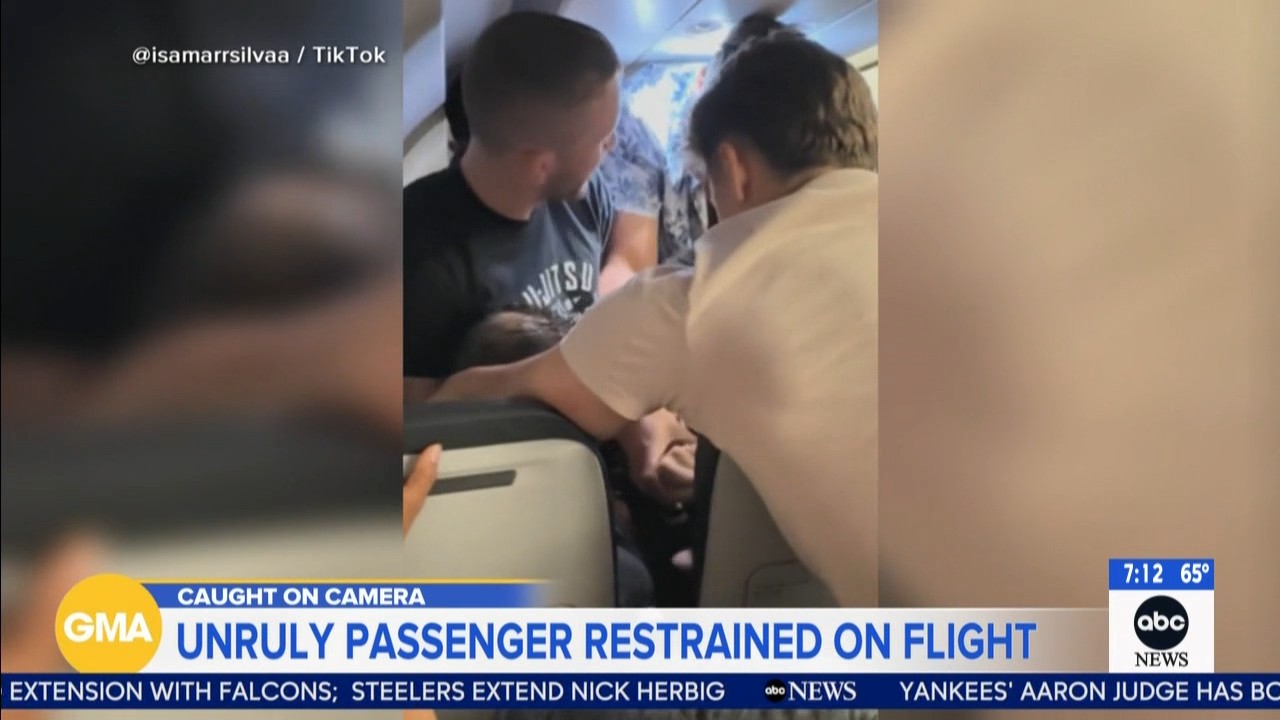 Source-feed image associated with Frontier passenger chokes off-duty flight attendant after trying to open exit door, cockpit: Police