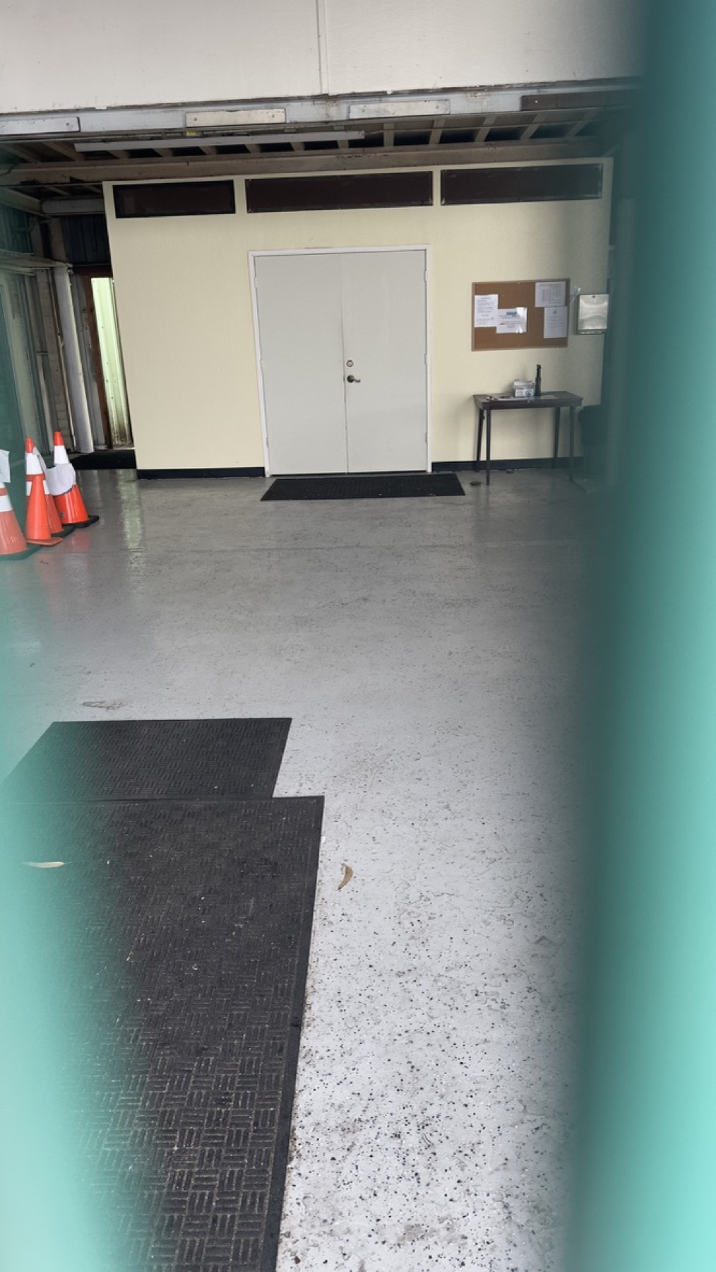 View through fencing toward a closed interior doorway at the Geng safe-parking site