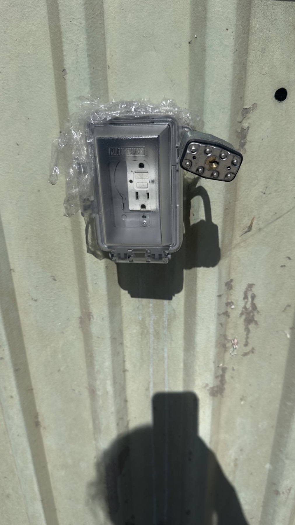 Exterior wall outlet at the Geng safe-parking site on May 13, 2026